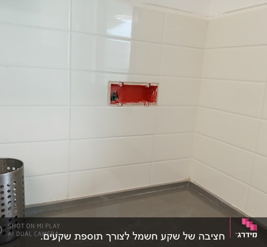 תיבת חשמל פתוחה בקיר אריחים לבנים